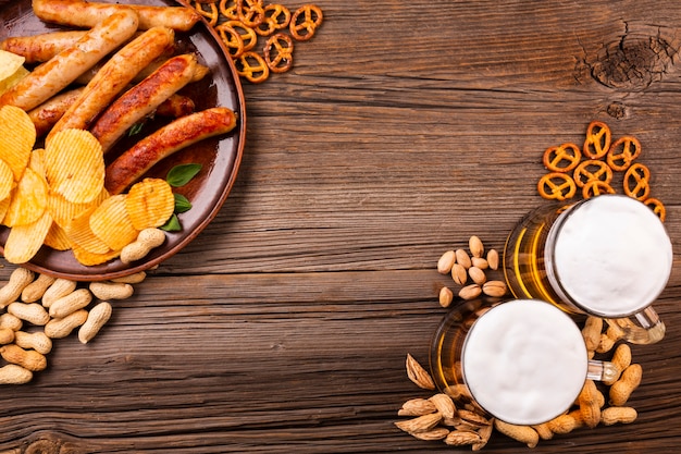 Top view beer with food on wooden table