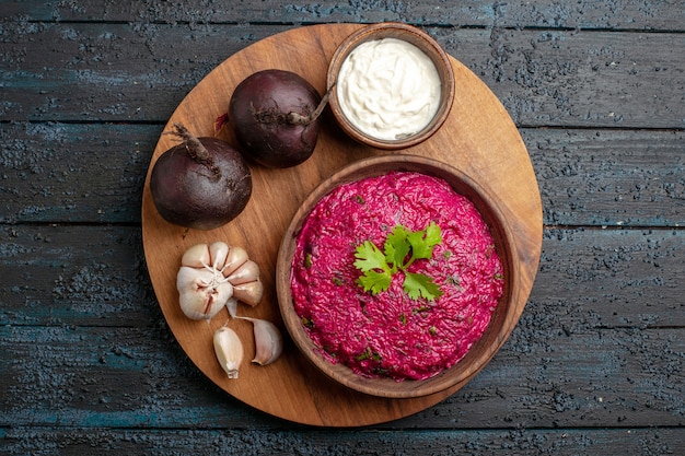 Foto gratuita vista dall'alto insalata di barbabietole con panna acida e aglio sulla scrivania scura