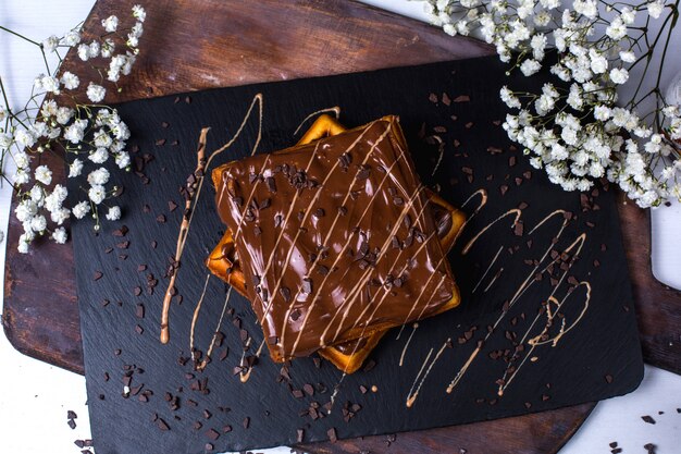 Top view of belgian waffle with chocolate on a wooden board