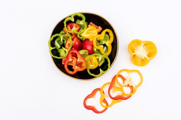 Top view bell pepper pepper sliced in black bowl on white  horizontal