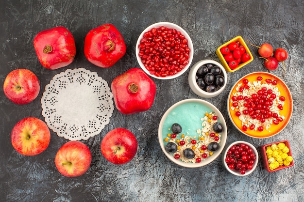 Top view of berries the appetizing colorful berries oatmeal apples pomegranates lace doily