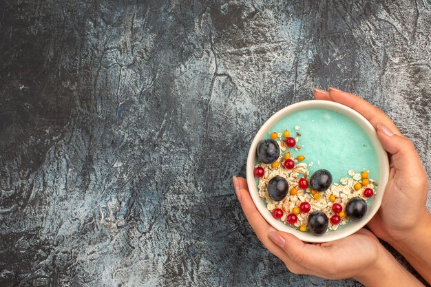 Top view of berries colorful berries oatmeal in the bowl in the hands