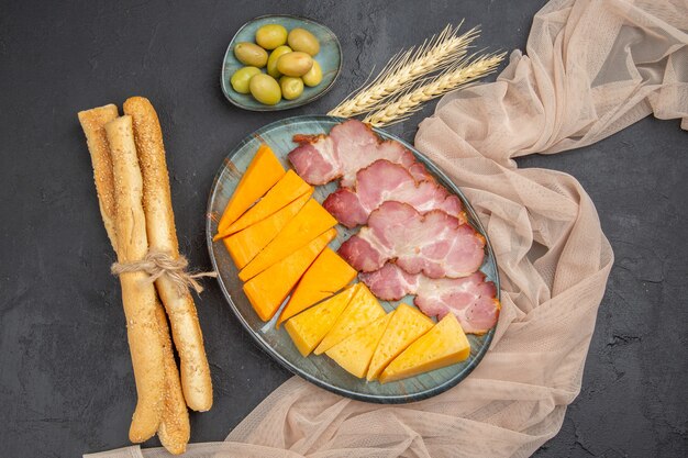 Top view of best delicious snacks for wine on a towel on a black background