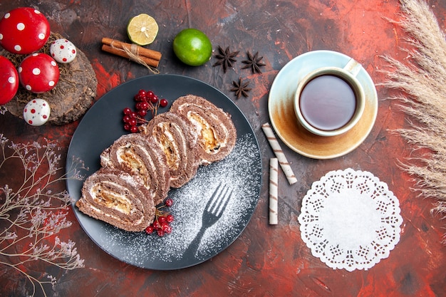 Free photo top view of biscuit rolls with cup of tea on dark surface