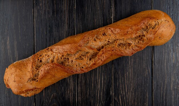 Top view of black baguette on wooden table