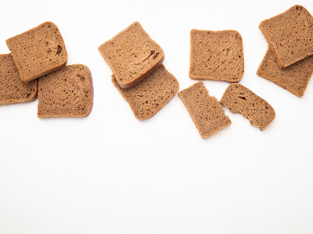 Top view of black bread slices on white background with copy space