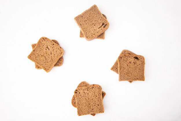 Top view of black bread slices on white background with copy space