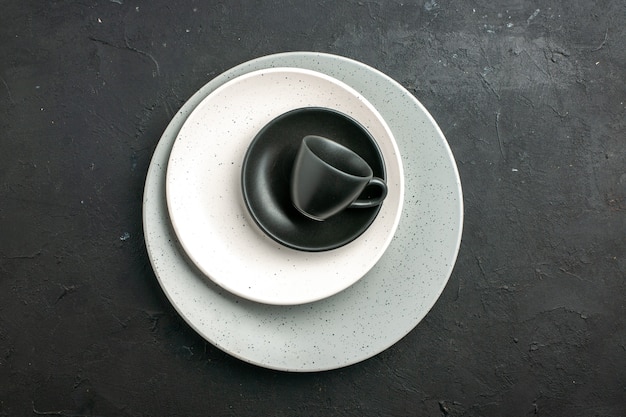 Free photo top view black cup saucer white plate on grey plate on dark surface free space