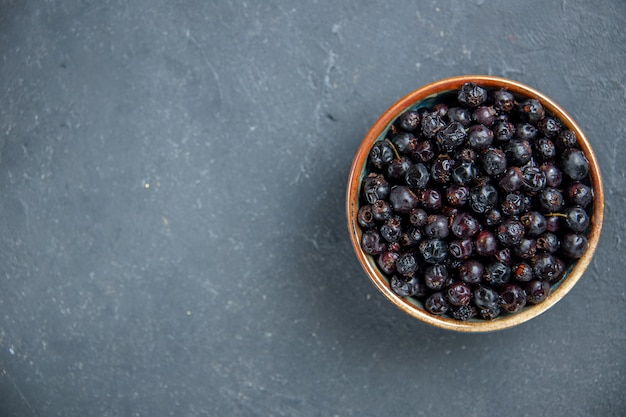 Top view black currant on dark surface with free space