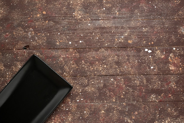 Free photo top view of black empty mold isolated on brown rustic, cake food oven wood wooden