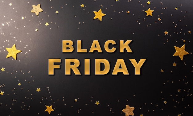 Top view of black friday sales discount concept in round frame of golden stars with the text on dark background.