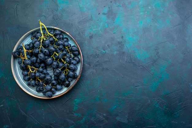 Free photo top view black grapes on dark blue