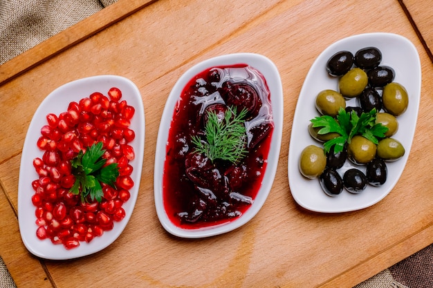 Vista dall'alto olive nere e verdi con salsa al melograno e melograno pelato