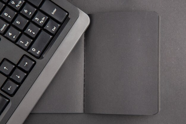 Top view black notebook keyboard on dark table