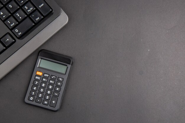 暗いテーブルのコピースペースに上面図の黒いオフィススタッフキーボード計算機