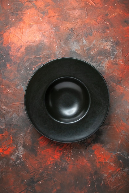 Foto gratuita piatto ovale nero vista dall'alto su sfondo rosso scuro