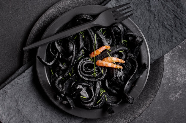 Top view black shrimp pasta with fork