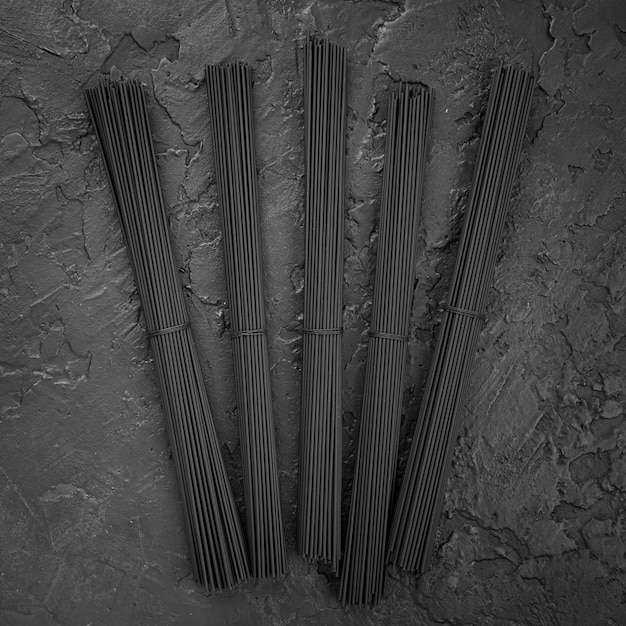 Top view of black spaghetti bundles on slate