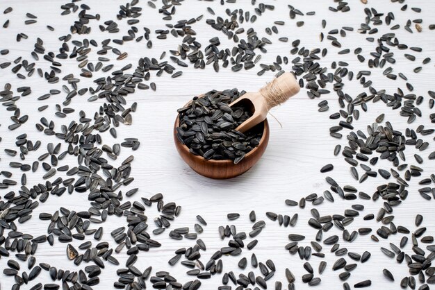 A top view black sunflower seeds fresh and tasty all over the white background grain sunflower seed snack