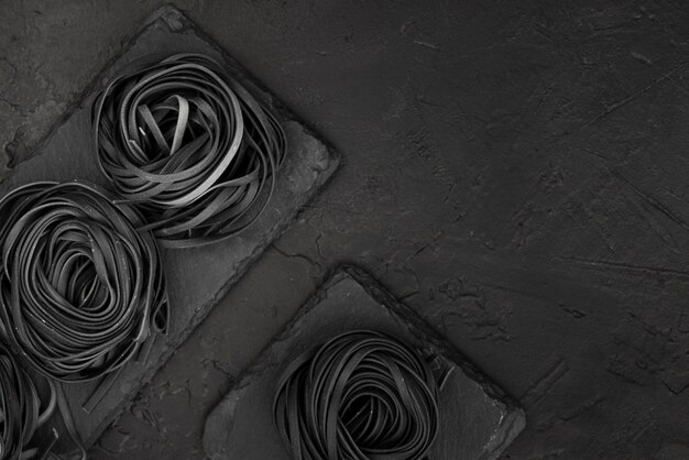 Top view of black tagliatelle on slate