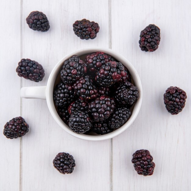 Top view of blackberry in a glass on a white surface