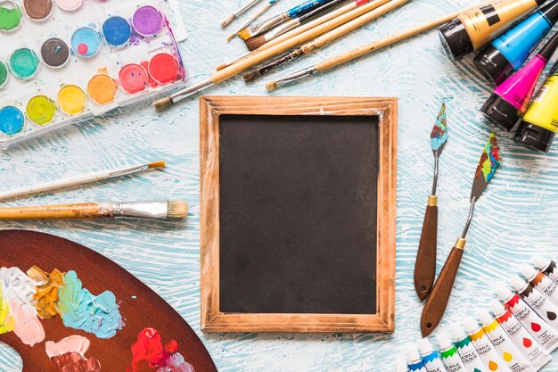 Top view blackboard surrounded by painting material