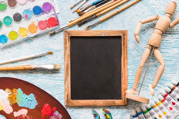 Top view blackboard surrounded by painting material