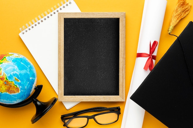 Top view of blackboard with academic cap and globe