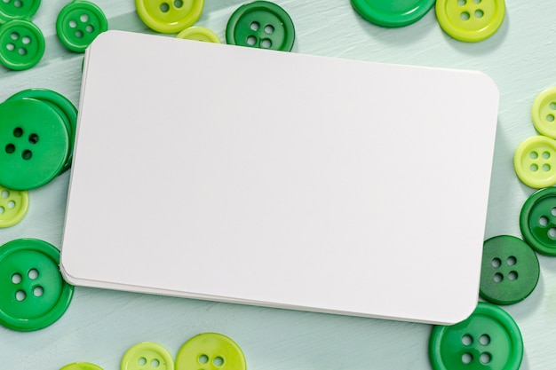 Free photo top view of blank card with green buttons