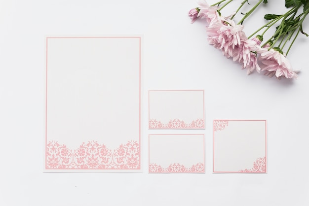 흰색 배경에 빈 카드와 핑크 꽃의 상위 뷰