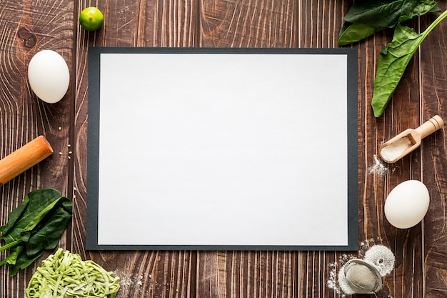 Top view of blank menu paper with eggs and greenery