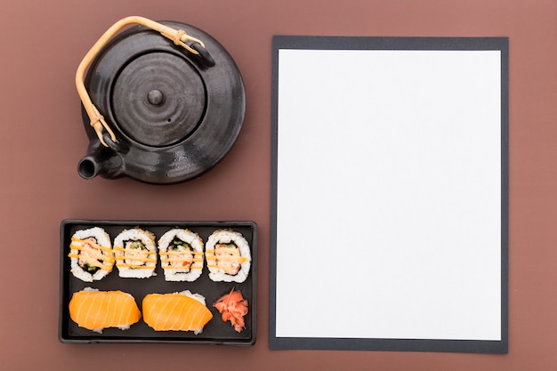 Вид сверху пустой меню бумаги с чайником и суши