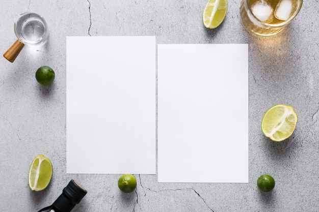 Top view of blank menu papers with limes and drink
