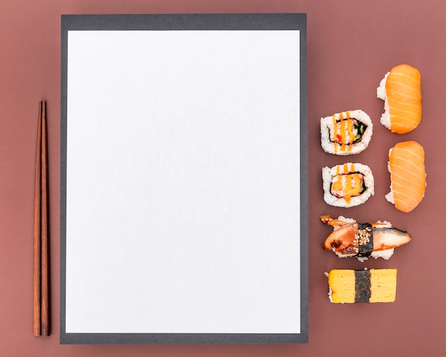 Top view of blank menu with chopsticks and sushi