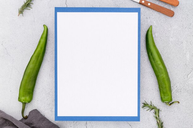 Top view of blank menu with peppers and cutlery