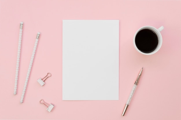 Top view of blank paper with pencils and coffee cup