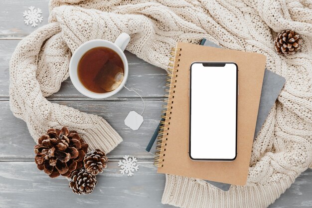 Top view blank phone on agendas with tea mug