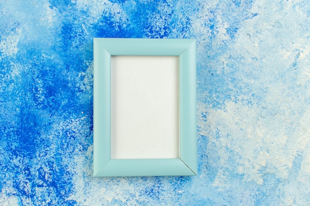 Top view blank photo frame on blue abstract