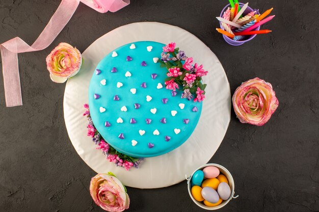 Голубой торт ко дню рождения с цветами и конфетами, вид сверху
