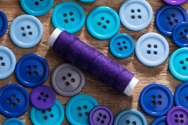 Top view of blue buttons and reel of thread