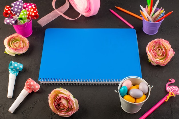 A top view blue copybook with different decorations on the dark desk book candy color photo