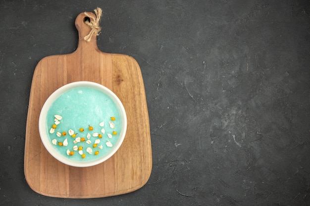 Top view blue iced dessert inside plate on dark table ice color cream