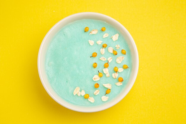 Free photo top view blue iced dessert inside plate on yellow table milk cereal color