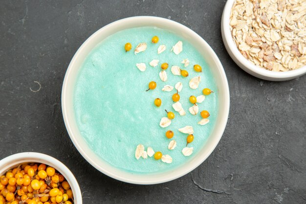 Top view blue iced dessert with raw muesli on a dark table cream ice color photo