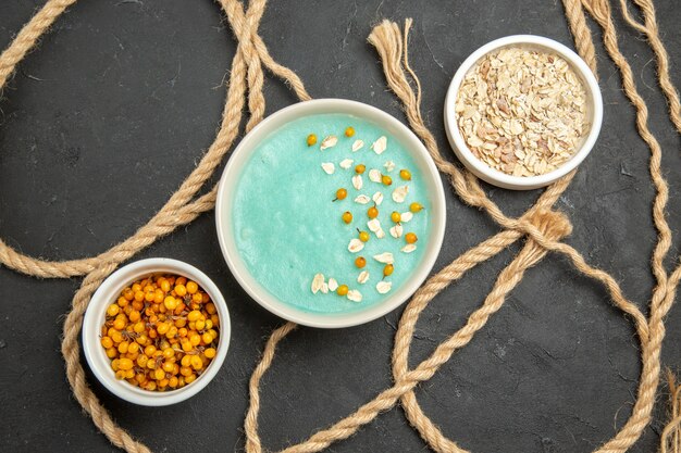 Top view blue iced dessert with raw muesli on dark table cream ice color