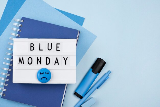 悲しい顔とノートブックと青い月曜日のライトボックスの上面図