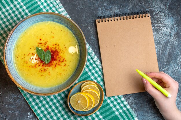 Top view of a blue pot with tasty soup served with mint