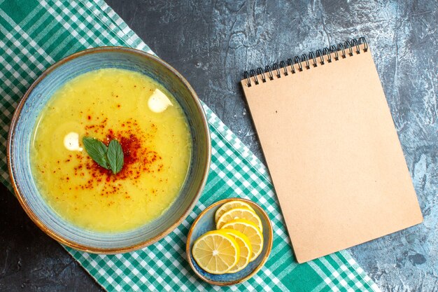 Top view of a blue pot with tasty soup served with mint