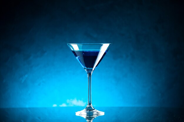 Top view of blue water in a glass goblet on middle on dark background