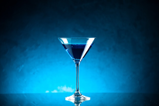 Top view of blue water in a glass goblet on middle on dark background